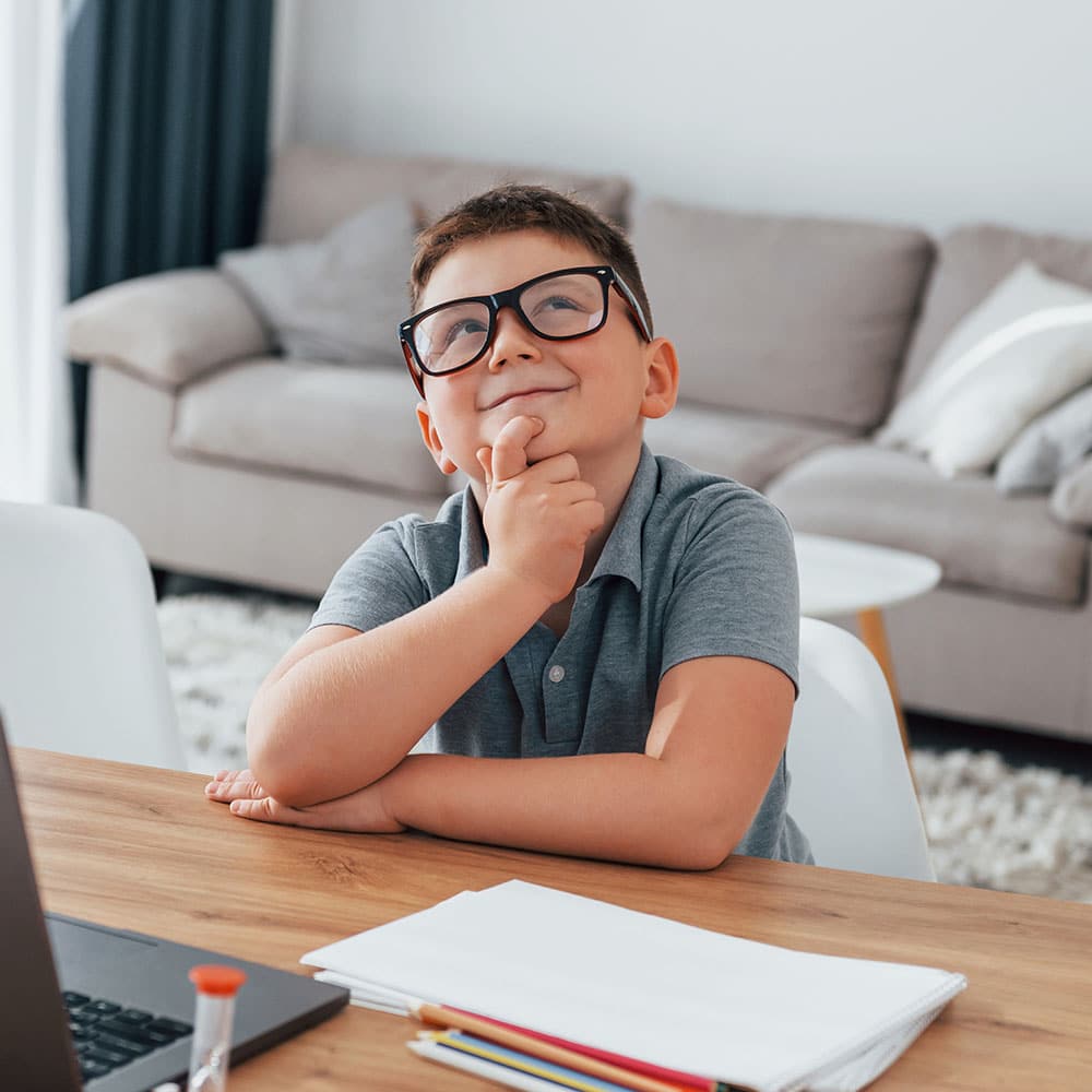 Little boy is having online lessons by using laptop - sofa - thinking - Homeschool Tutor